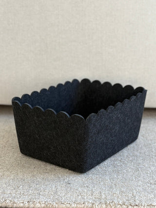 Black scalloped-edge basket on a neutral background