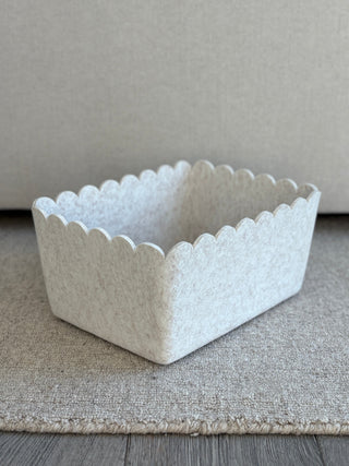 White textured rectangular basket on a gray surface with a neutral background